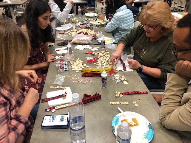 Students and teachers decorating crafts around a table