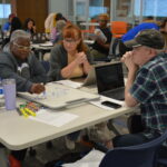 Thumbnail of http://A%20group%20of%20teachers%20work%20together%20at%20a%20project%20table.