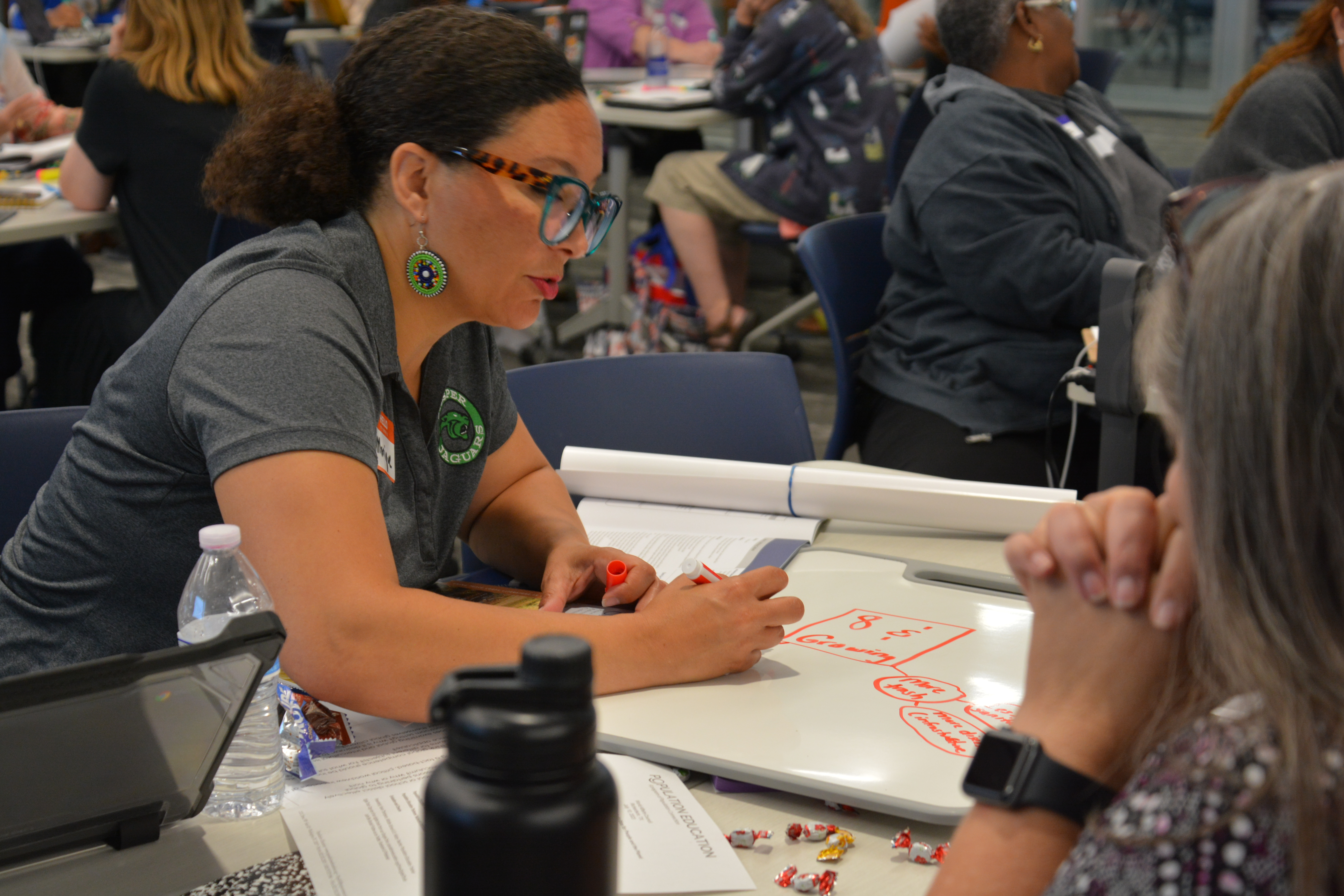 A teacher writes at an event table.