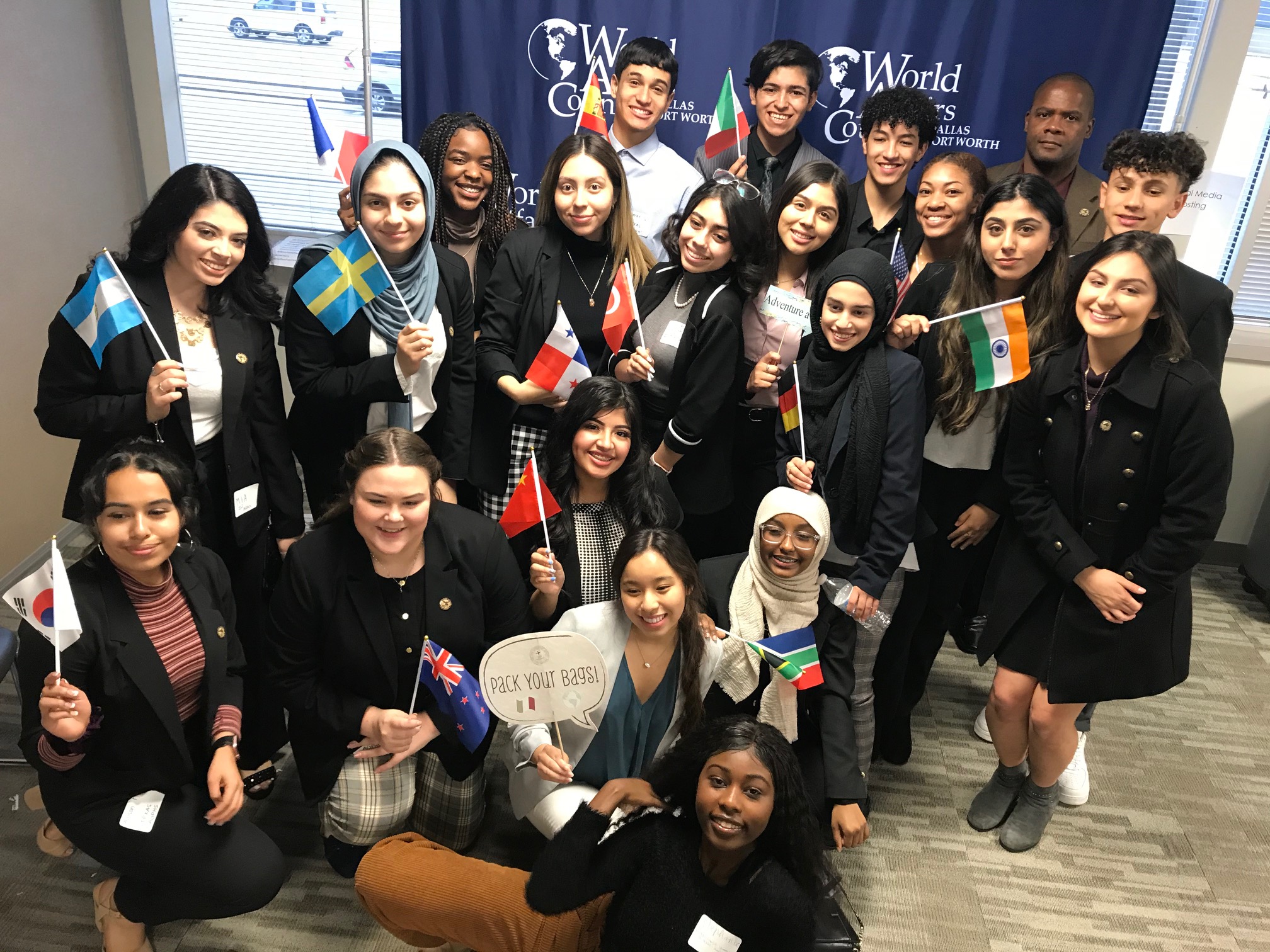 Students pose, holding small flags.