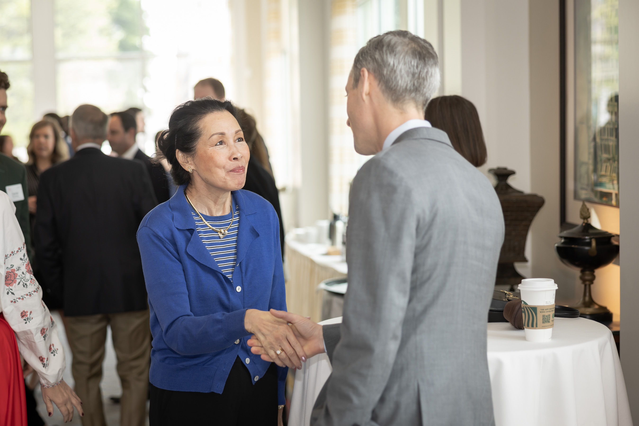Program participant (Maisie Heiken) greets the keynote speaker (Ned Price)