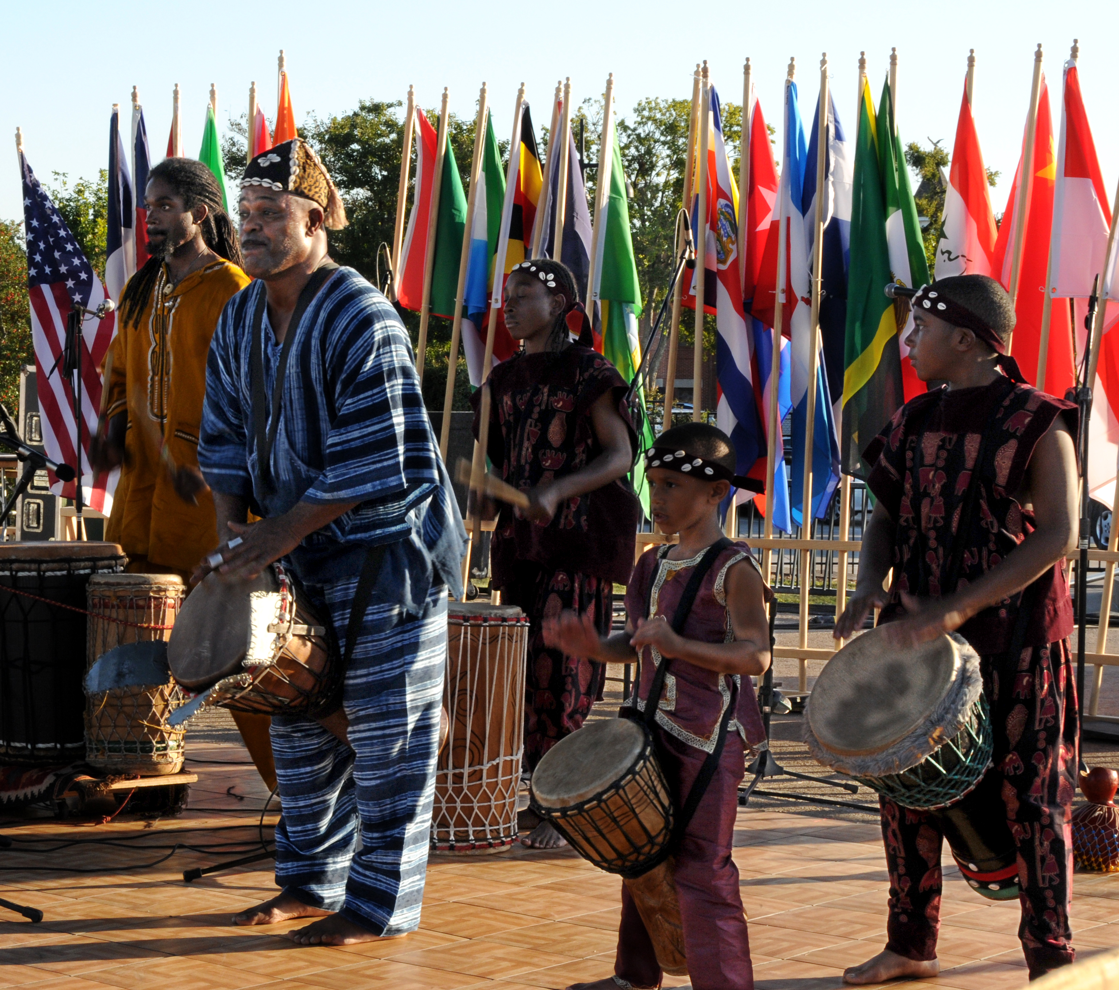 musicians on a stage with flags of the world behind them